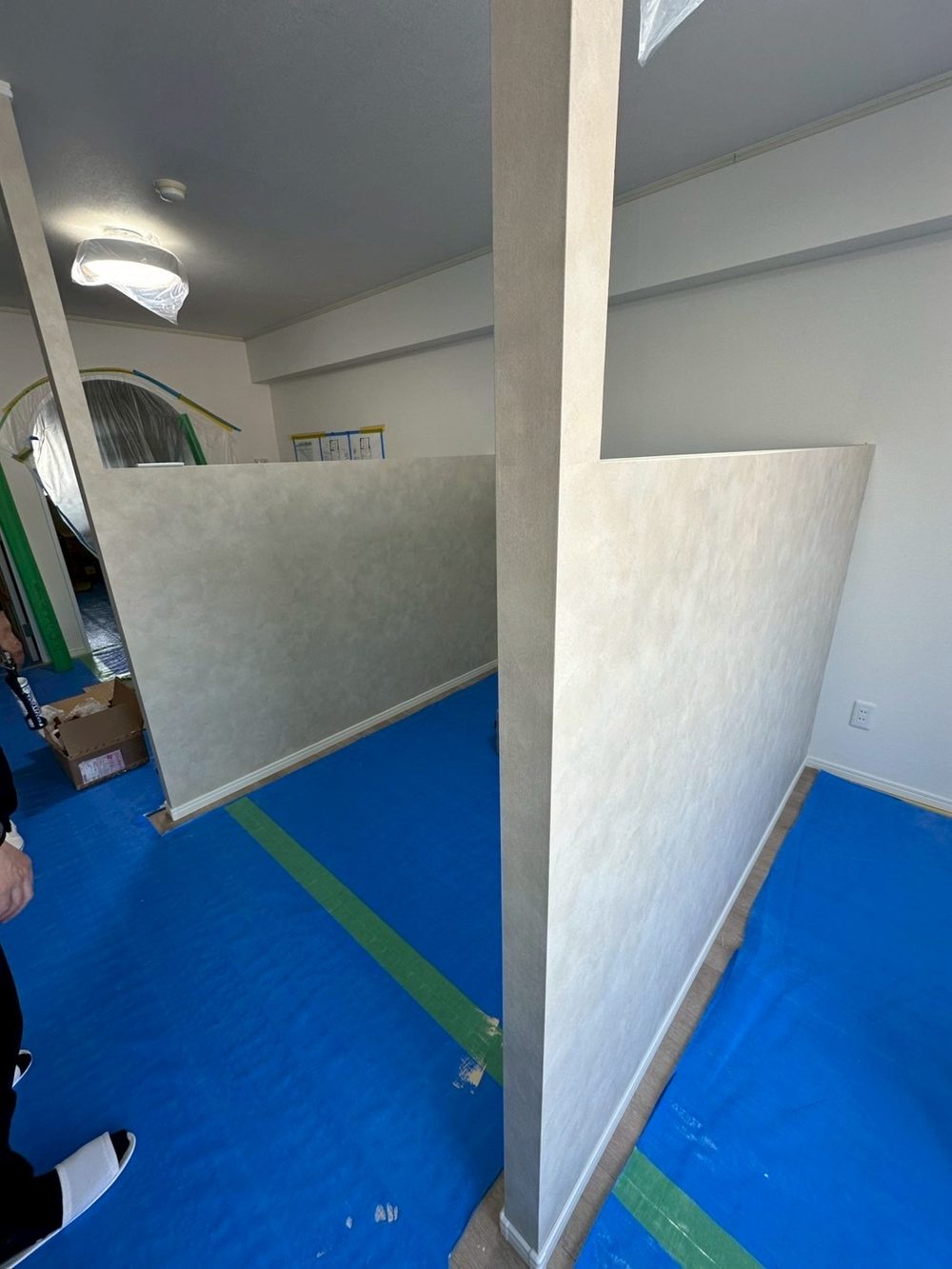 マンションの一室に立てた間仕切り壁。天井まで届かない高さで、施術スペースを半個室に分けている